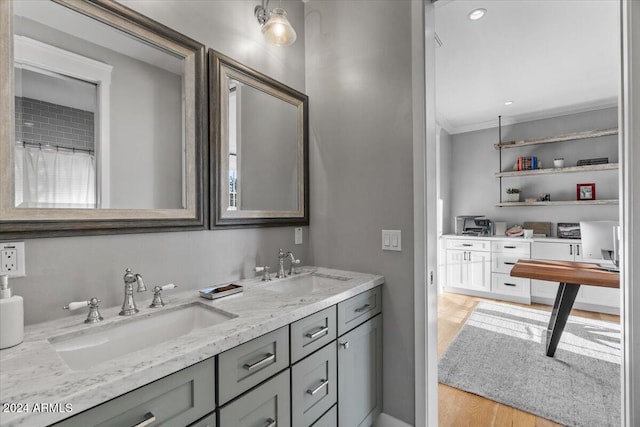 bathroom featuring hardwood / wood-style floors, vanity, and ornamental molding