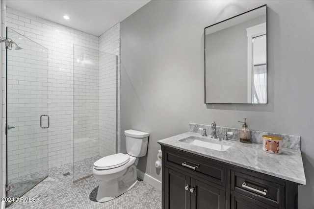 bathroom featuring tile patterned flooring, vanity, toilet, and walk in shower