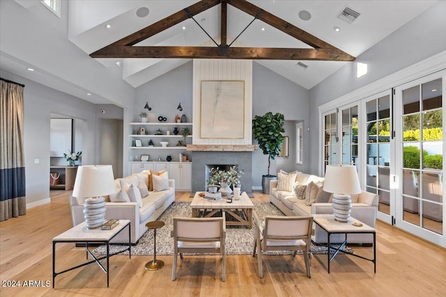 living room featuring beam ceiling, high vaulted ceiling, and light wood-type flooring