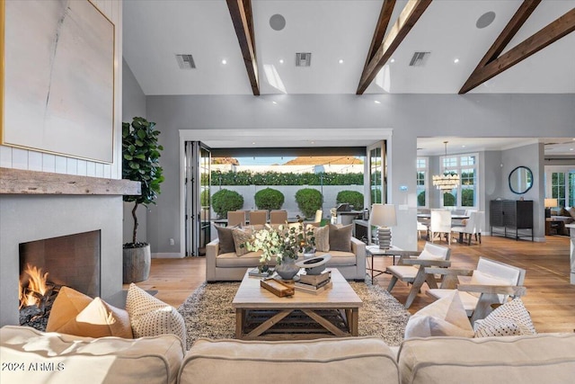 living room with beam ceiling, a chandelier, high vaulted ceiling, and light hardwood / wood-style floors