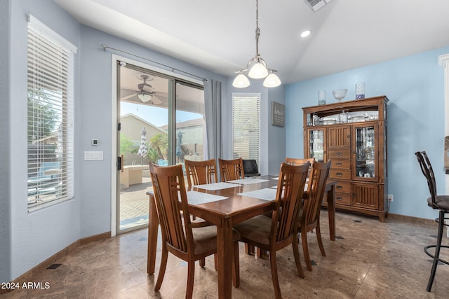 dining area featuring an inviting chandelier, vaulted ceiling, and a wealth of natural light