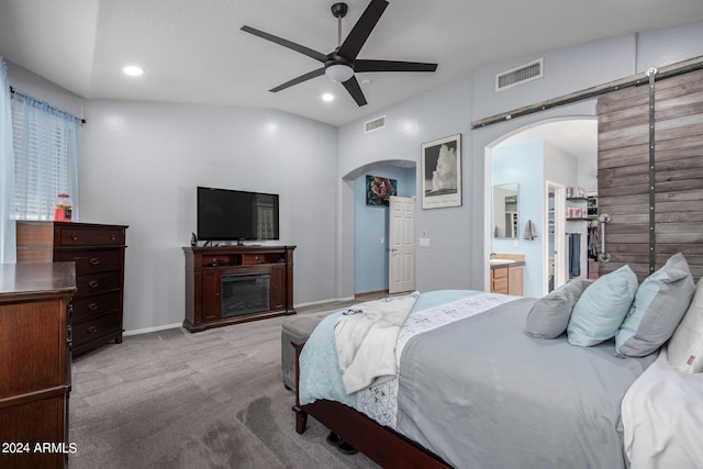 carpeted bedroom featuring ceiling fan, vaulted ceiling, and ensuite bath