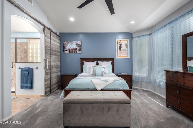 carpeted bedroom with ceiling fan, lofted ceiling, and a barn door