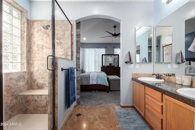 bathroom featuring vanity, ceiling fan, a healthy amount of sunlight, and a shower with shower door