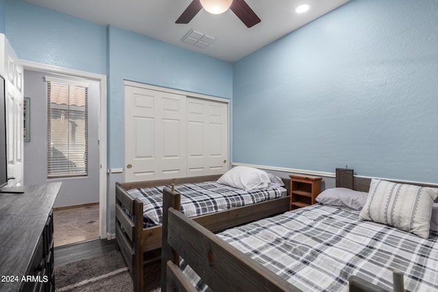 bedroom with dark hardwood / wood-style flooring, a closet, and ceiling fan