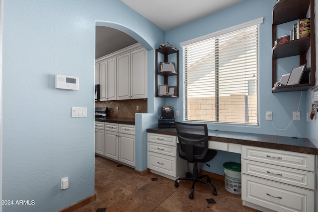 office featuring built in desk and dark tile patterned floors