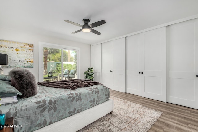 bedroom with access to outside, wood finished floors, and a ceiling fan