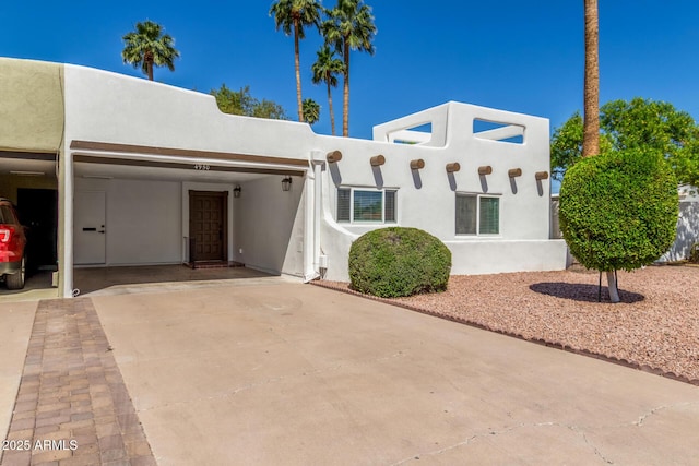 pueblo revival-style home with stucco siding