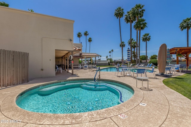 community pool featuring a patio and fence