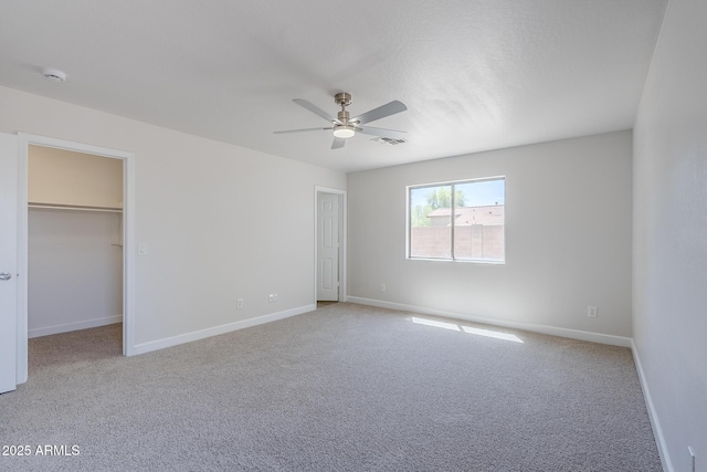 16159 W Maui Ln, Surprise, AZ 85379 - unfurnished bedroom featuring carpet, baseboards, a walk in closet, and ceiling fan