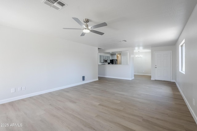 16159 W Maui Ln, Surprise, AZ 85379 - unfurnished living room featuring wood finished floors, baseboards, a ceiling fan, and a chandelier