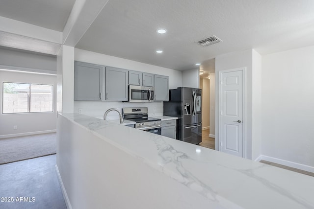 16159 W Maui Ln, Surprise, AZ 85379 - kitchen featuring appliances with stainless steel finishes, gray cabinetry, light stone counters, baseboards, and recessed lighting