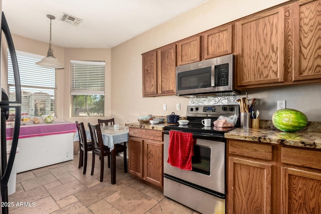 5654 W Vineyard Rd, Laveen, AZ 85339 - kitchen with appliances with stainless steel finishes, brown cabinets, stone tile flooring, hanging light fixtures, and stone countertops