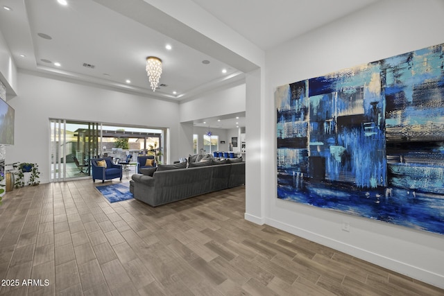 living room with an inviting chandelier, a towering ceiling, and a raised ceiling