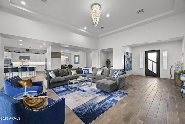 living room featuring a raised ceiling and a notable chandelier