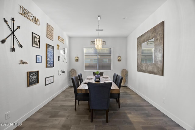 dining area with dark wood-type flooring and a notable chandelier