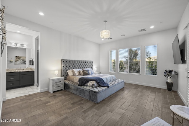 bedroom featuring connected bathroom and an inviting chandelier