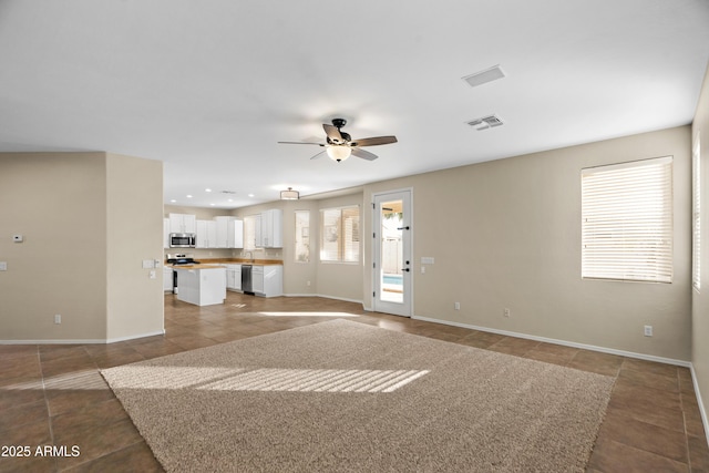 unfurnished living room featuring ceiling fan and light tile patterned floors