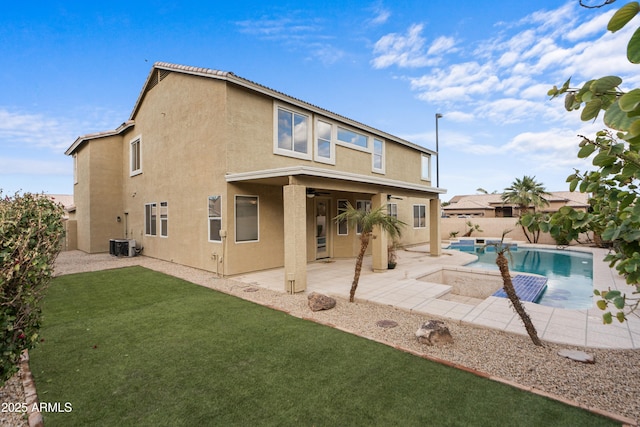 back of property with a fenced in pool, a patio area, a lawn, and central AC