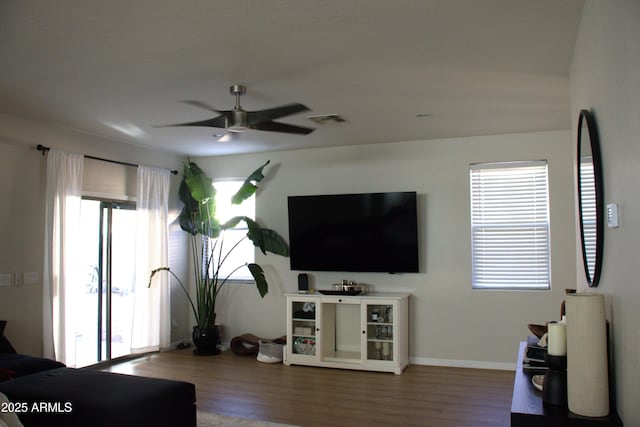 living room featuring wood-type flooring and ceiling fan