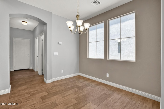3036 N Acacia Way, Buckeye, AZ 85396 - spare room with arched walkways, light wood-type flooring, and a chandelier
