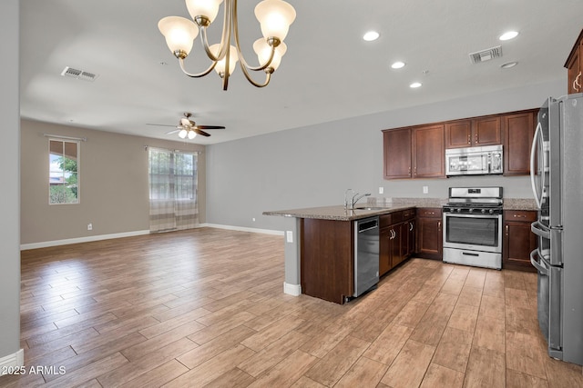 3036 N Acacia Way, Buckeye, AZ 85396 - kitchen featuring appliances with stainless steel finishes, open floor plan, a ceiling fan, light stone countertops, and recessed lighting