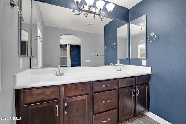 3036 N Acacia Way, Buckeye, AZ 85396 - bathroom featuring double vanity, a chandelier, and a textured wall