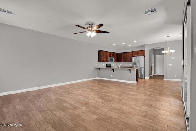 3036 N Acacia Way, Buckeye, AZ 85396 - unfurnished living room with ceiling fan, recessed lighting, a chandelier, light wood-style floors, and arched walkways