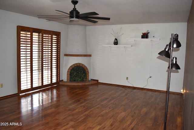 unfurnished living room featuring hardwood / wood-style flooring, ceiling fan, and a fireplace