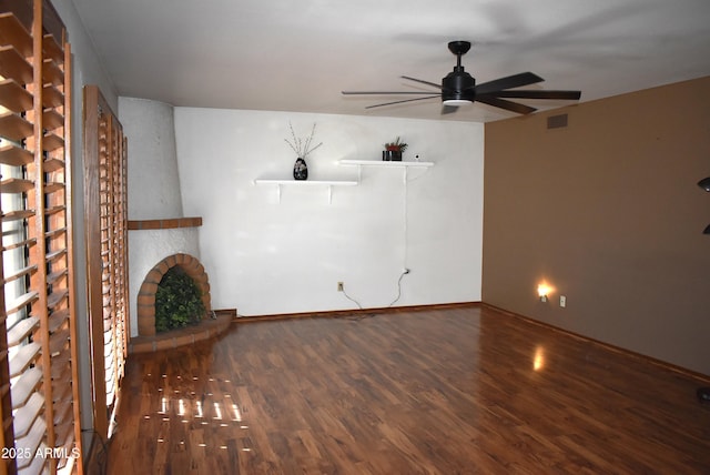 unfurnished living room featuring ceiling fan, a large fireplace, and wood-type flooring