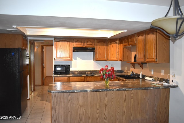 kitchen with sink, kitchen peninsula, pendant lighting, light tile patterned floors, and black appliances