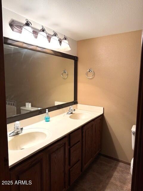 bathroom with vanity, a textured ceiling, and toilet