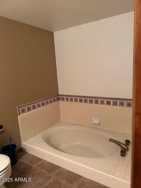 bathroom with toilet, a bath, and tile patterned floors