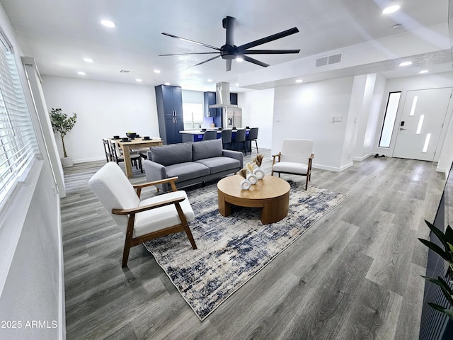 living area featuring baseboards, visible vents, ceiling fan, wood finished floors, and recessed lighting