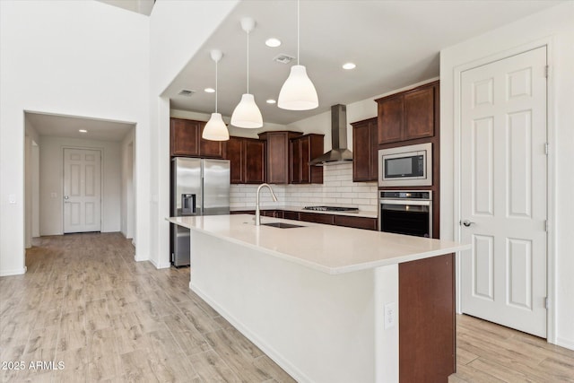 22987 E Pummelos Rd, Queen Creek, AZ 85142 - kitchen featuring wall chimney exhaust hood, decorative backsplash, appliances with stainless steel finishes, a sink, and light wood finished floors