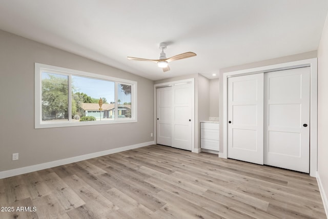 1920 N Cavalier Dr, Tempe, AZ 85288 - unfurnished bedroom featuring two closets, baseboards, light wood-style flooring, and a ceiling fan