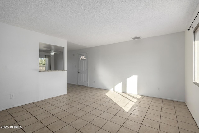 unfurnished room with light tile patterned flooring and a textured ceiling