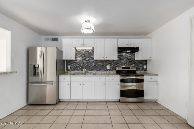 kitchen with appliances with stainless steel finishes, light stone countertops, sink, and white cabinets