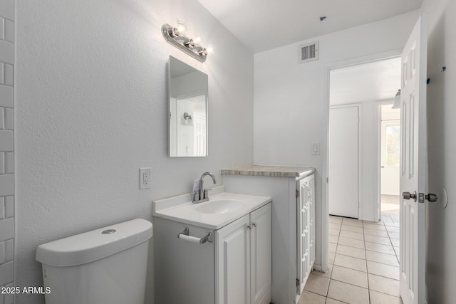 bathroom featuring vanity, toilet, and tile patterned flooring