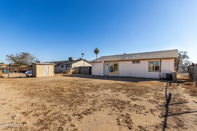 rear view of property featuring a storage shed