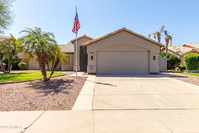 view of front facade featuring a garage, driveway, stucco siding, and a tile roof