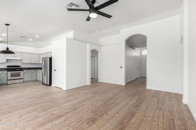 unfurnished living room featuring arched walkways, visible vents, light wood-style flooring, and ceiling fan
