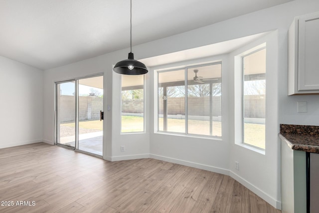 unfurnished dining area with light wood finished floors and baseboards