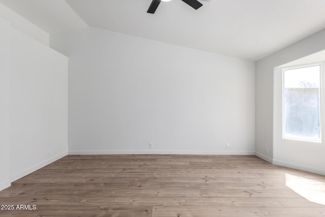 spare room with light wood-style flooring, ceiling fan, baseboards, and lofted ceiling