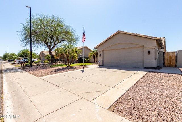 ranch-style home with stucco siding, a tile roof, a gate, an attached garage, and driveway