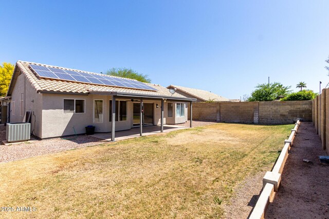 rear view of property featuring a patio, stucco siding, central AC unit, a fenced backyard, and ceiling fan