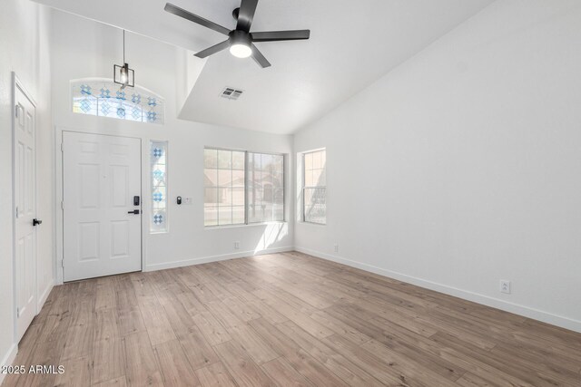 foyer entrance with visible vents, plenty of natural light, ceiling fan, light wood-style floors, and high vaulted ceiling