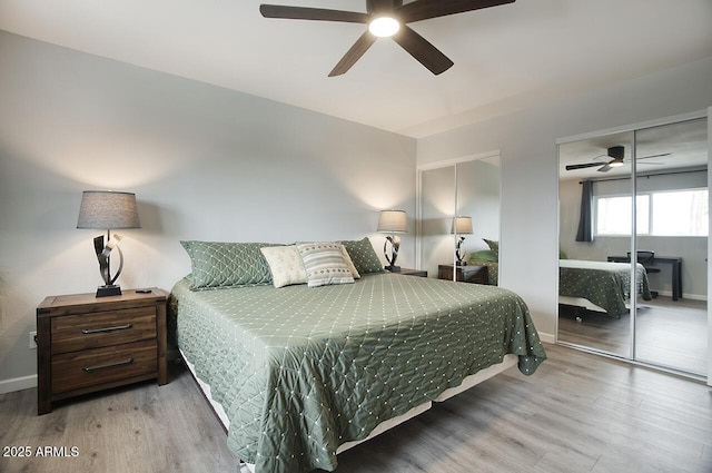 bedroom with ceiling fan, two closets, and light wood-type flooring