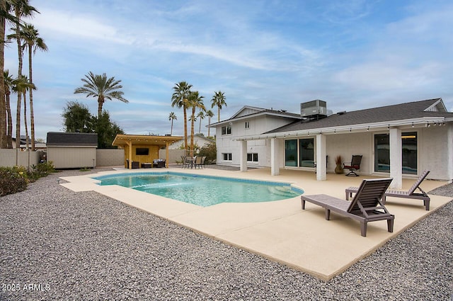 view of swimming pool featuring a shed, central AC unit, and a patio