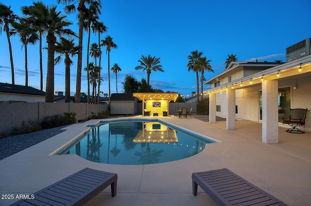 pool at dusk with a patio area